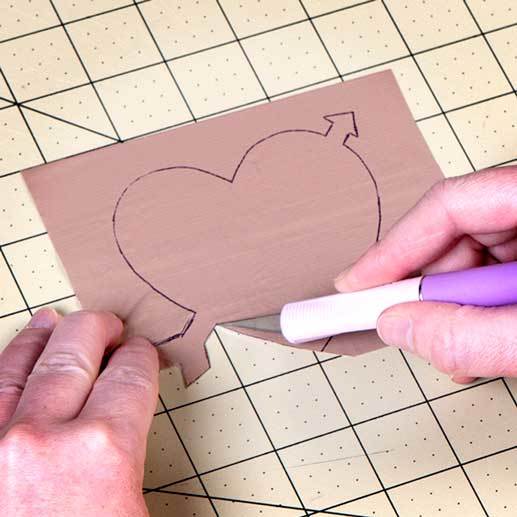 Duck Tape fabric sheet with a heart and arrow through it drawn on the sheet. Then cut out the heart